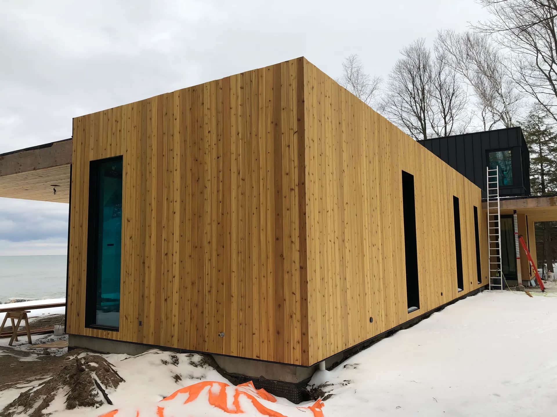 Modern cedar-clad custom home over the water in South Georgian Bay by JTL Projects